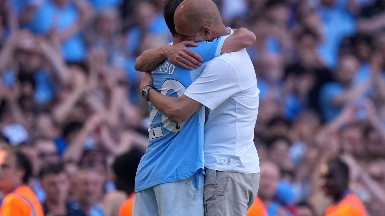 Manchester City's head coach Pep Guardiola hugs Manchester City's Bernardo Silva as he played last match for the team during a Premier League soccer match between Manchester City and Aston Villa in Manchester, England, Sunday, May 24, 2026.