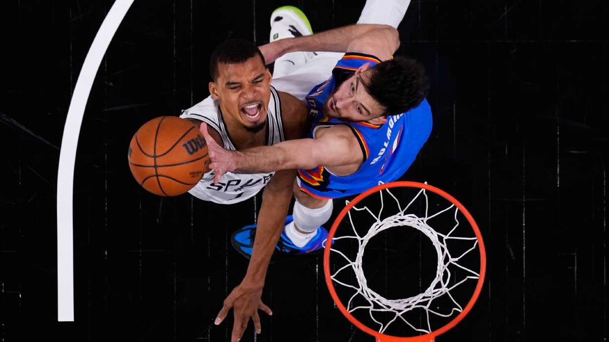 San Antonio Spurs forward Victor Wembanyama, left, scores against Oklahoma City Thunder center Chet Holmgren, right, during the first half in Game 4 in the Western Conference finals NBA basketball playoffs series in San Antonio, Sunday, May 24, 2026.
