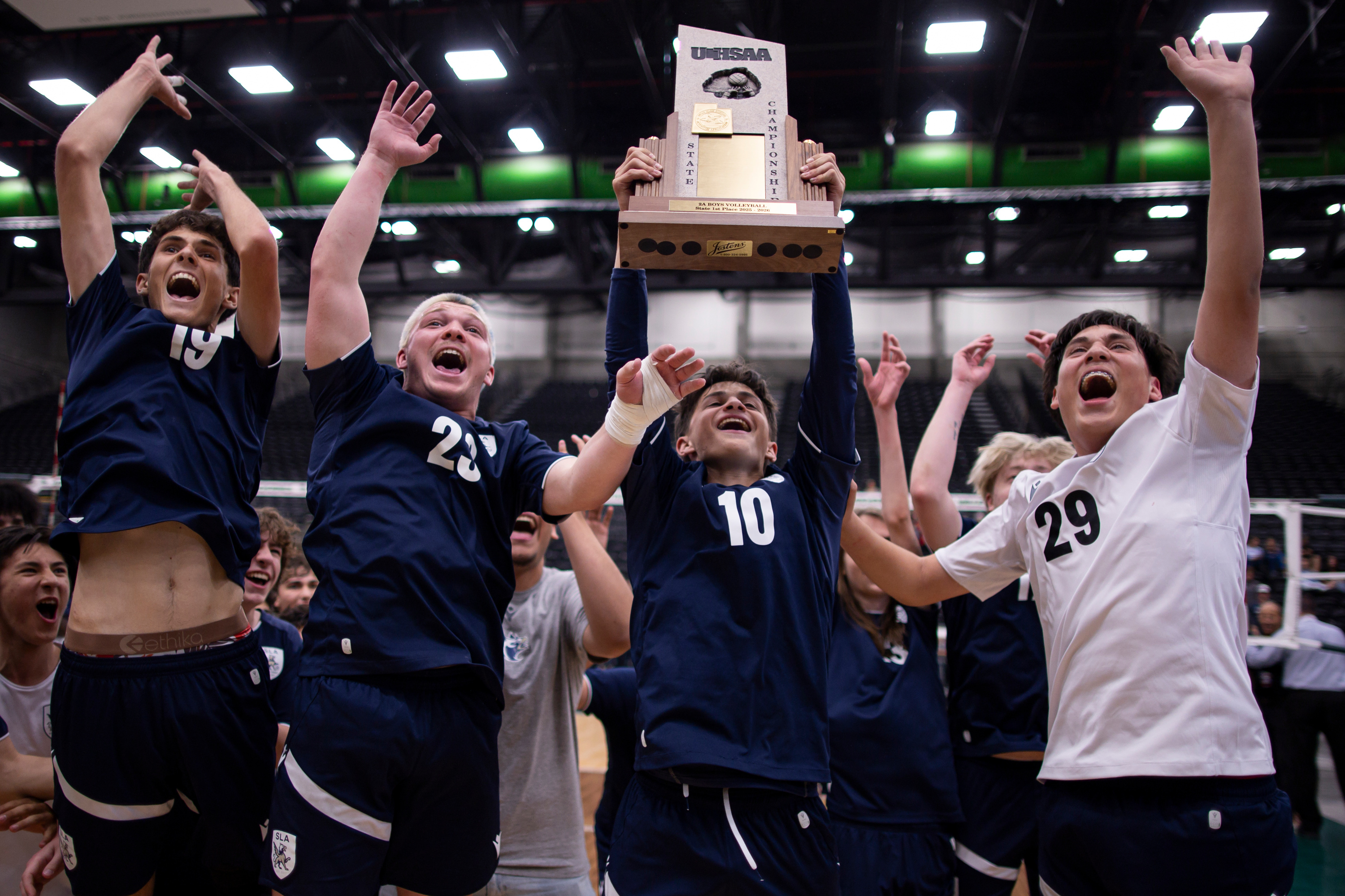 Salt Lake Academy’s Brock Rhodes (19), Cooper Rushton (23), Ryder Harrison (10) and Damian Rivadeneira (29) celebrate after defeating American Heritage to win the boys 2A state volleyball championship at the UCCU Center in Orem on Saturday, May 9, 2026.