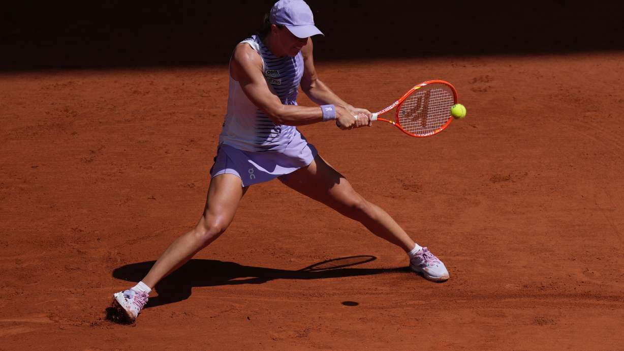 Iga Swiatek of Poland returns to Emerson Jones of Australia during their first round women's singles tennis match at the French Open tennis tournament in Paris, Monday, May 25, 2026.