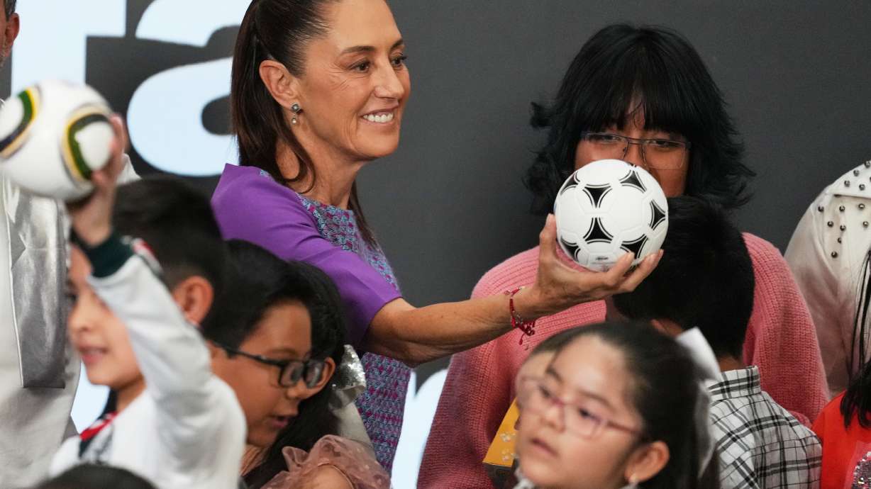 Mexican President Claudia Sheinbaum gives a soccer ball to children after her daily morning press conference at the National Palace in Mexico City, Thursday, April 30, 2026.