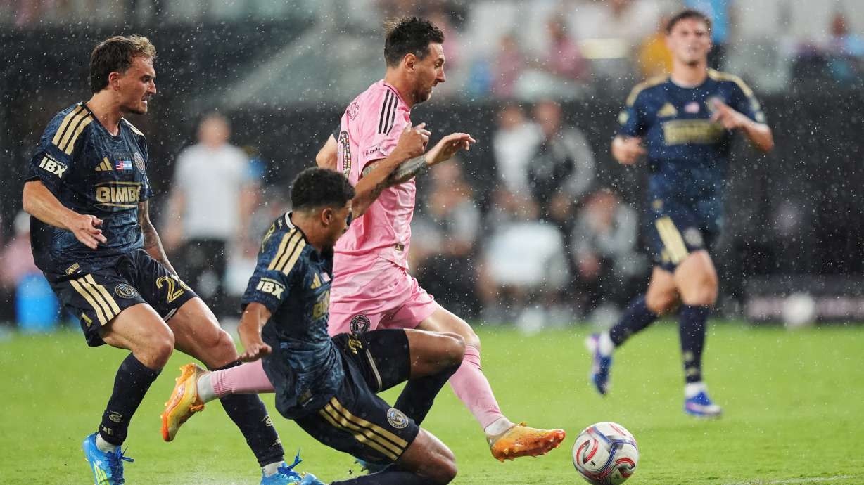 Inter Miami forward Lionel Messi, center, drives forward under pressure from Philadelphia Union forward Augustin Anello, left, and defender Nathan Harriel, bottom, during the second half of an MLS soccer match, Sunday, May 24, 2026, in Miami.