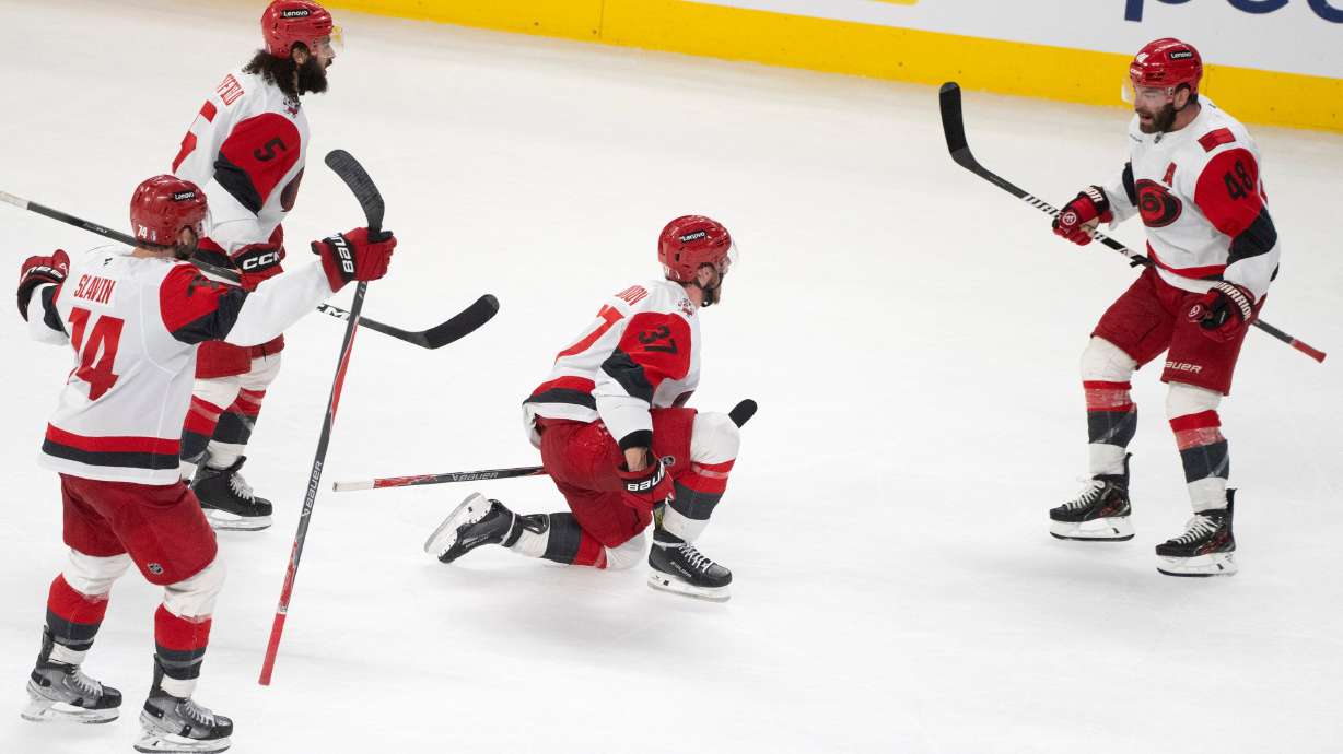 Carolina Hurricanes' Andrei Svechnikov (37) celebrates with teammates Jaccob Slavin (74), Jalen Chatfield (5) and Jordan Martinook (48) after a goal by teammate Sebastian Aho (not shown) during overtime of Game 3 of the Eastern Conference finals NHL hockey Stanley Cup playoff series against the Montreal Canadiens in Montreal, Monday, May 25, 2026.