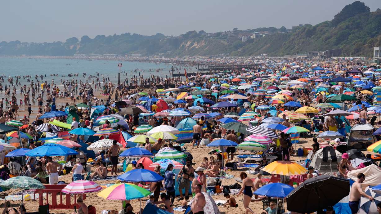 People visit Bournemouth beach, south England, Monday. A spring heatwave is scorching parts of Western Europe, breaking temperature records and triggering government warnings.
