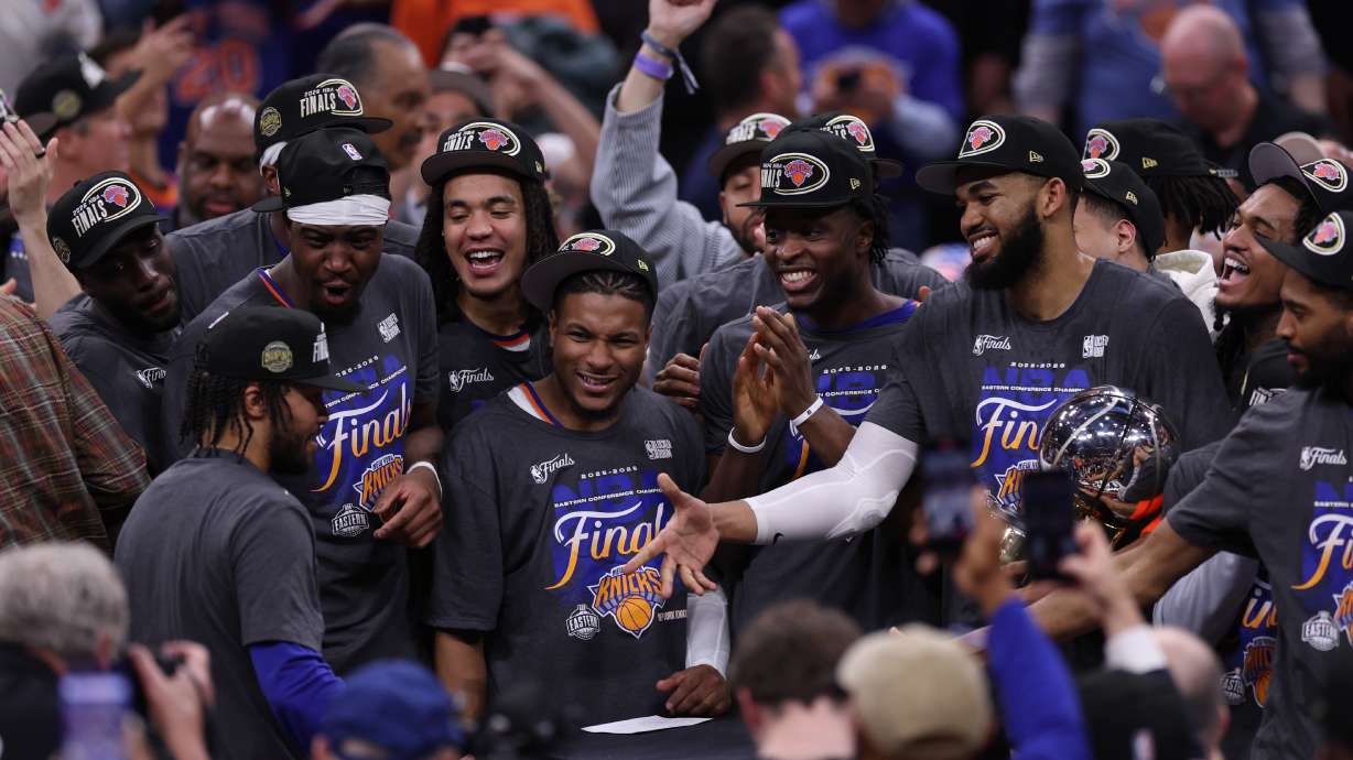 New York Knicks players celebrate with guard Jalen Brunson, left, after he was awarded with the MVP trophy after winning Game 4 in the Eastern Conference finals NBA basketball playoffs series against the Cleveland Cavaliers in Cleveland, Monday, May 25, 2026.