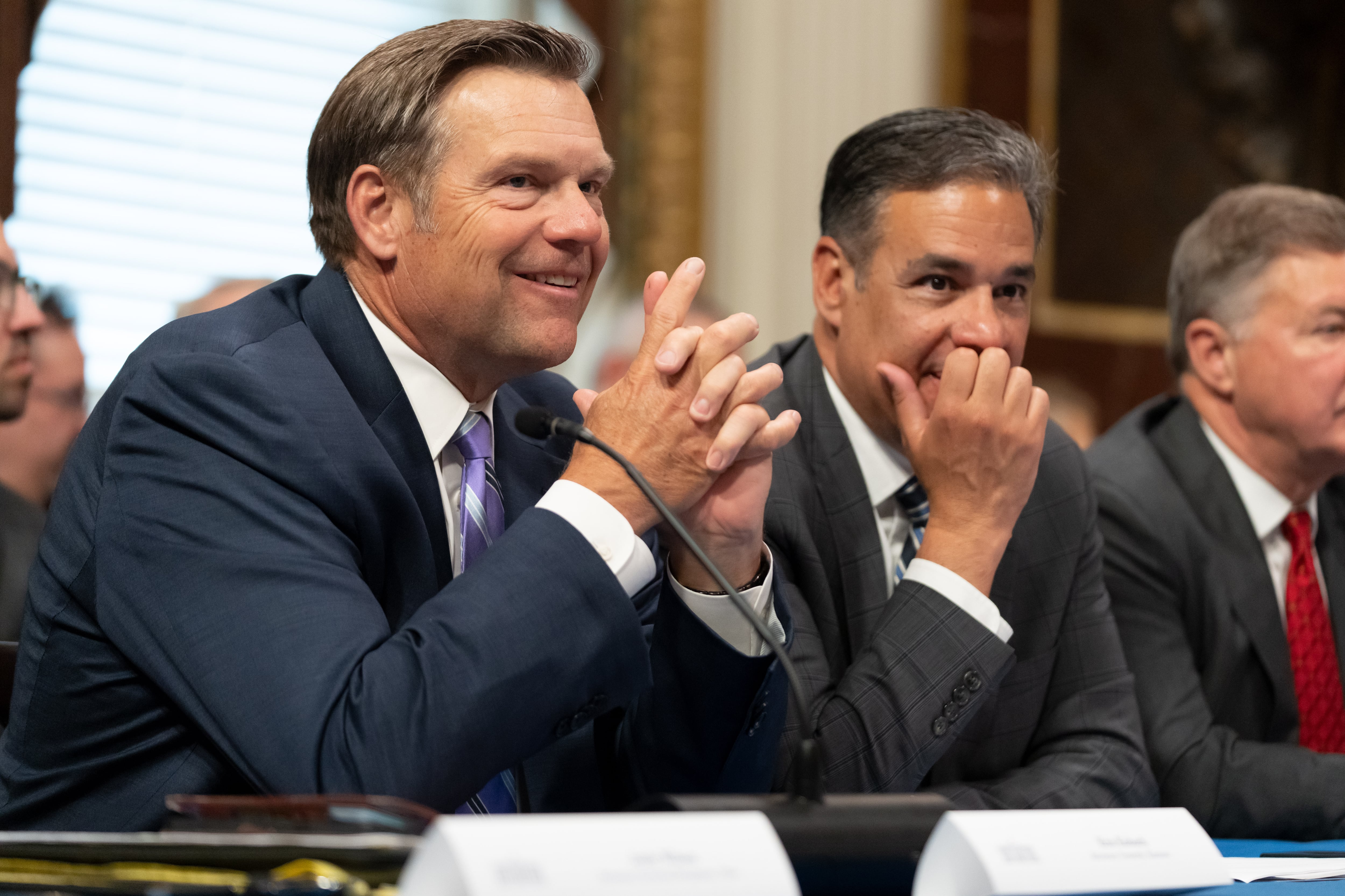 Kansas Attorney General Kris Kobach talks with Idaho Attorney General Raul Labrador before an event with Vice President JD Vance in the Eisenhower Executive Office Building, Tuesday, in Washington. Only two Democratic attorneys general were present at the event, citing short notice.