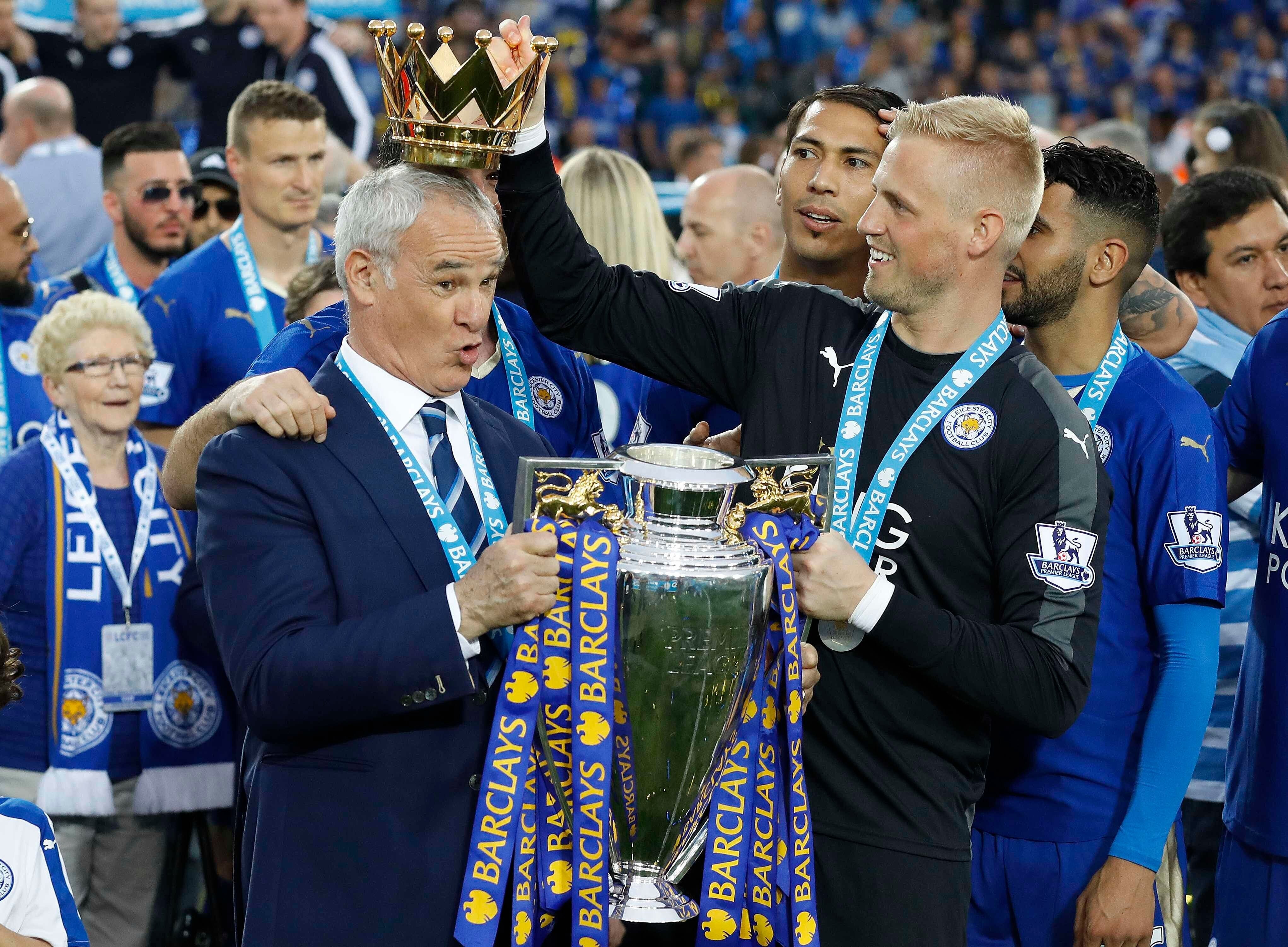 FILE - Leicester City team manager Claudio Ranieri has the crown of the trophy placed on his head by Leicester goalkeeper Kasper Schmeichel as they celebrate becoming the English Premier League soccer champions at King Power stadium in Leicester, England, May 7, 2016. 