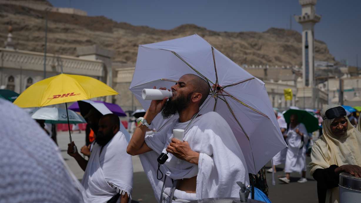 A Muslim pilgrim drinks water as pilgrims walk on their way to cast pebbles at pillars in the symbolic stoning of the devil, the last rite of the annual Hajj, in Mina near the holy city of Mecca, Saudi Arabia, Wednesday.