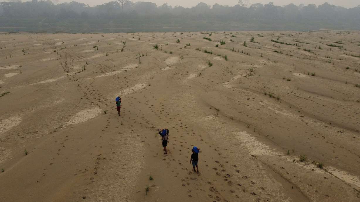 Residents transport drinking water to the Paraizinho community, along the dry Madeira River, a tributary of the Amazon River, in Amazonas state, Brazil, Sept. 8, 2024. The United Nations is warning of higher average global temperatures in the years to come.