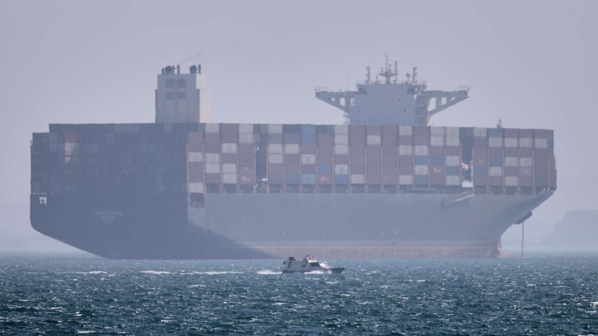 A container ship sits at anchor as a small motorboat passes in the Strait of Hormuz, Iran, May 2. U.S. and Iranian negotiators have reached a tentative agreement to extend the ceasefire by 60 days and launch talks on Iran's nuclear program.