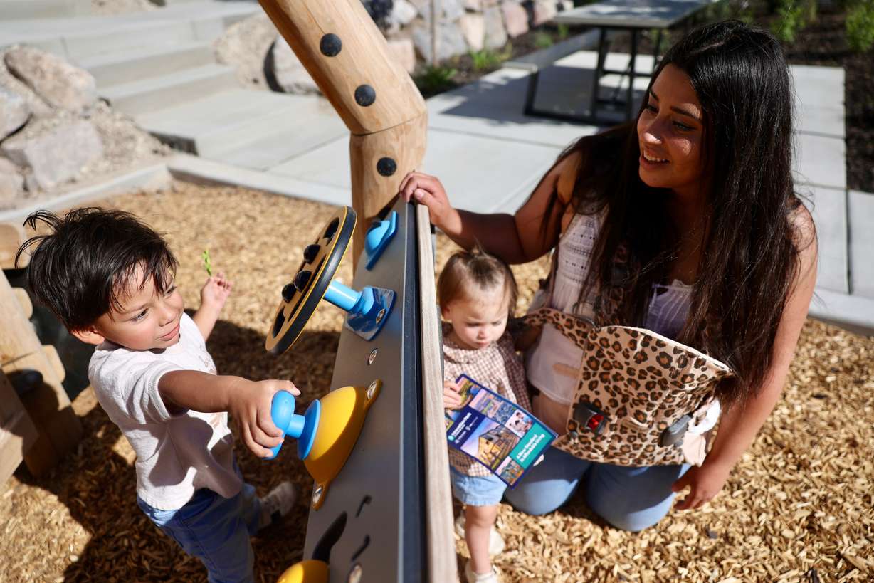 Zander Wanlass, Mae Wanlass and Marie Wanlass play on the playground during the grand opening of Innovation Park at Holbrook Farms and the Lehi Rippy Literacy Center in Lehi on Thursday.