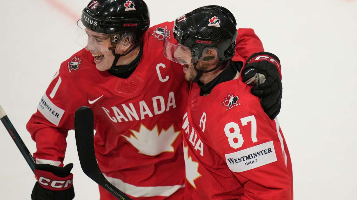 Canada's Sidney Crosby (87) celebrates with Macklin Celebrini (71) after scoring a goal during the third period of the 2026 IIHF Men's Ice Hockey World Championship quarterfinal match between Canada and United States, in Fribourg, Switzerland, Thursday, May 28, 2026.