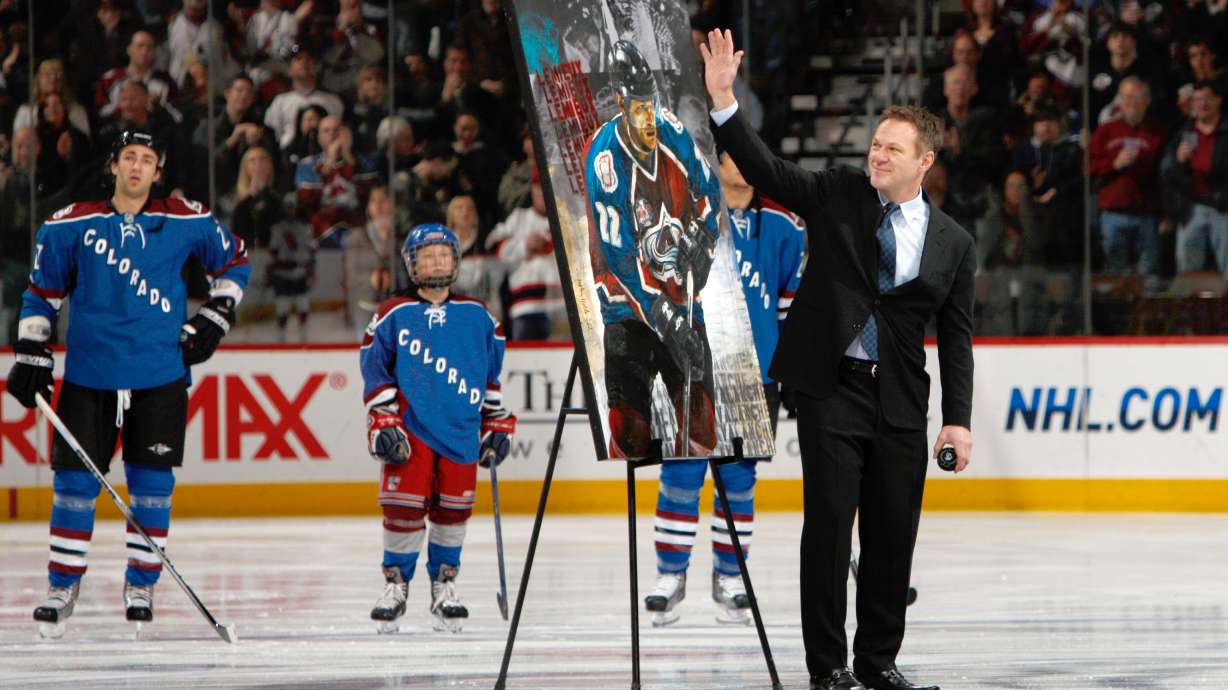 FILE - Retired Colorado Avalanche player Claude Lemieux waves to fans as he is honored for his years on the ice before the Avalanche host the New Jersey Devils in the first period of an NHL hockey game in Denver, Saturday, Jan. 16, 2010.