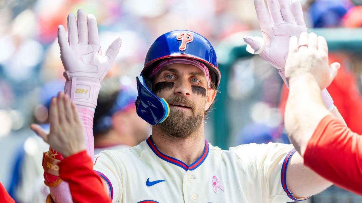 Philadelphia Phillies' Bryce Harper is congratulated in the dugout after he hit a solo home run in the first inning of a baseball game against the Colorado Rockies, Sunday, May 10, 2026, in Philadelphia.