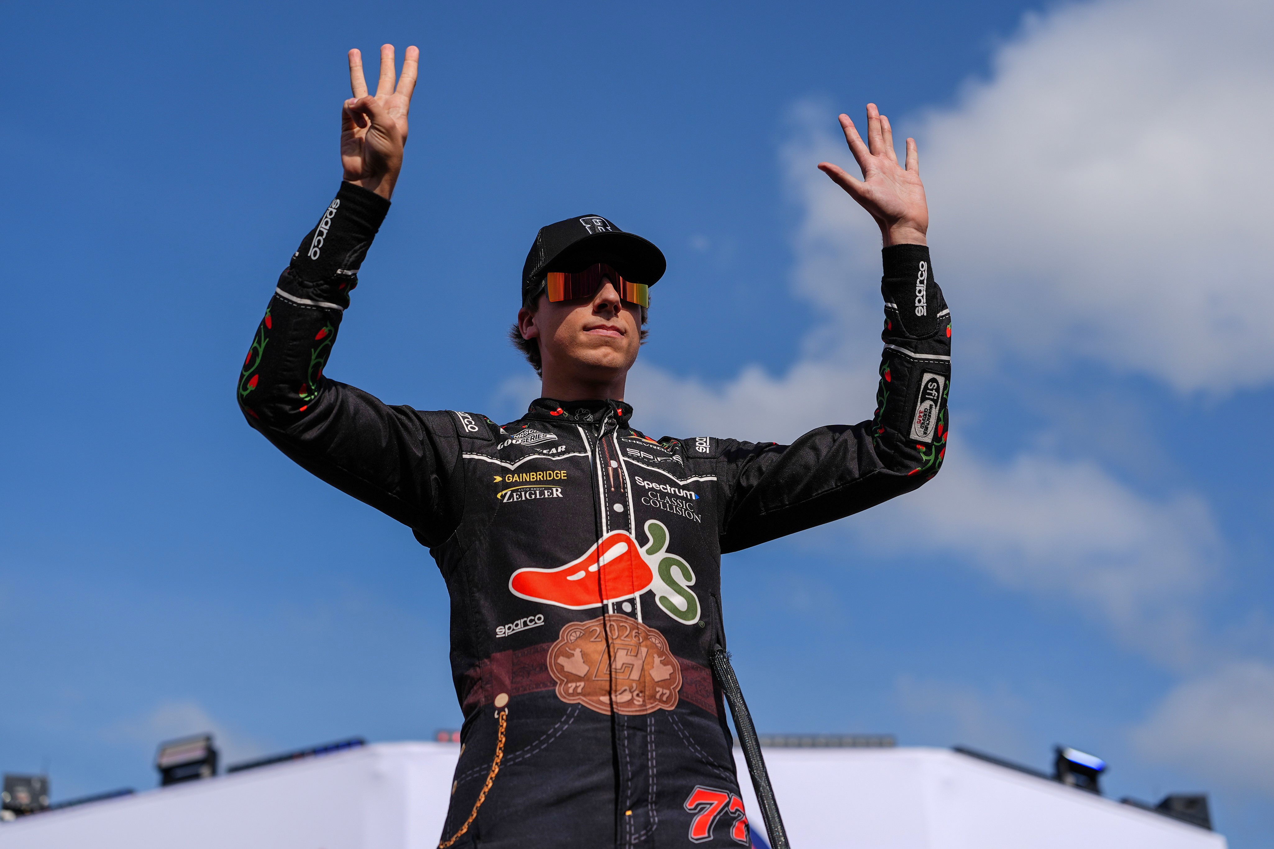 Carson Hocevar holds up eight fingers in honor of late driver Kyle Busch prior to a NASCAR Cup Series auto race, Sunday, May 24, 2026, in Charlotte, N.C. 