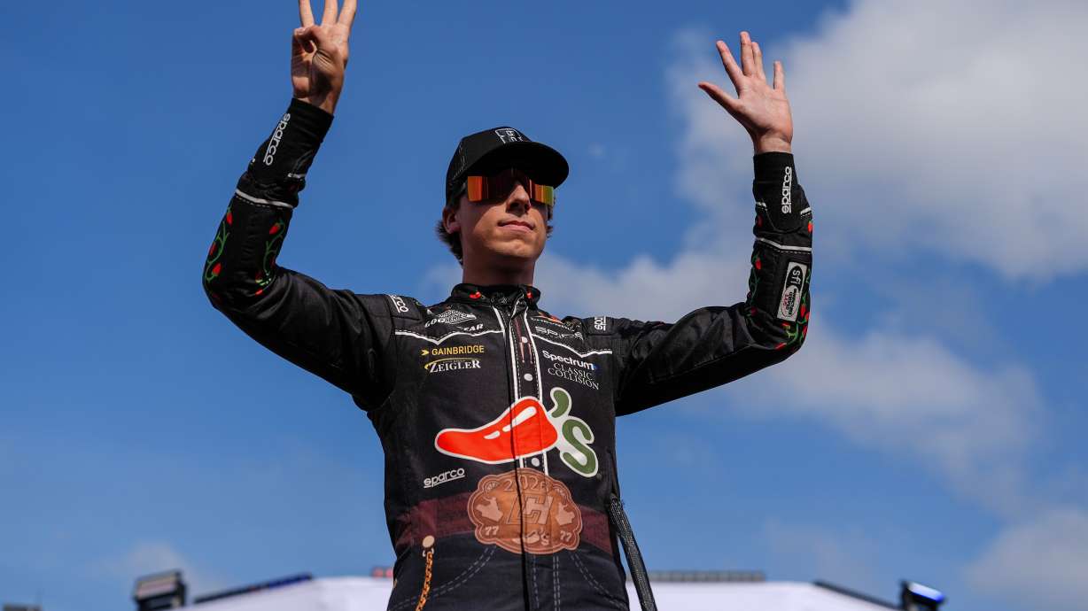Carson Hocevar holds up eight fingers in honor of late driver Kyle Busch prior to a NASCAR Cup Series auto race, Sunday, May 24, 2026, in Charlotte, N.C.