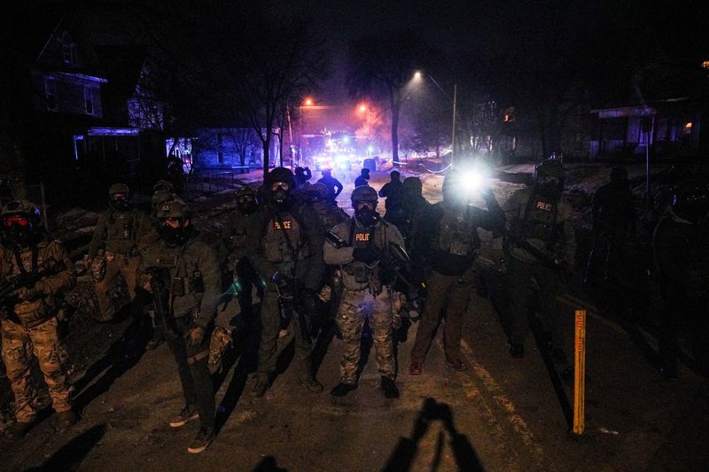 Federal agents stand guard, as tensions rise after federal law enforcement agents were involved in a shooting incident, a week after a U.S. Immigration and Customs Enforcement agent fatally shot Renee Nicole Good, in north Minneapolis, Minnesota, Jan. 14.