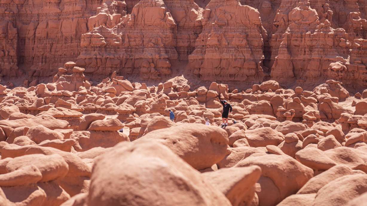 People hike across the sandstone hoodoos scattered across Goblin Valley State Park in Emery County on May 23, 2021. The Bureau of Land Management approved a plan Friday to bring power to the popular state park through a new power line.