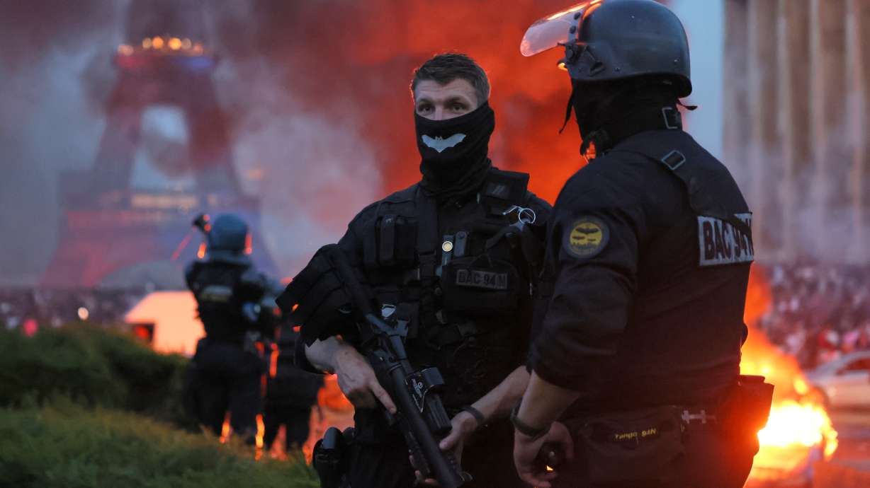 A car burns and fireworks explode as police watch PSG supporters celebrate in Paris, Saturday, May 30, 2026 after the Champions League final soccer match between Paris Saint-Germain and Arsenal that's being played in Budapest, PSG won the game.