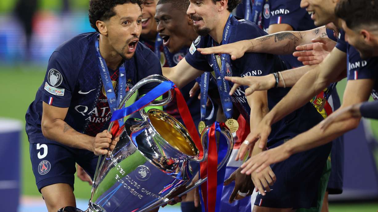 PSG players celebrate with a trophy after the Champions League final soccer match between Paris Saint-Germain and Arsenal in Budapest, Hungary, Saturday, May 30, 2026. AP Photo/Armin Durgut)