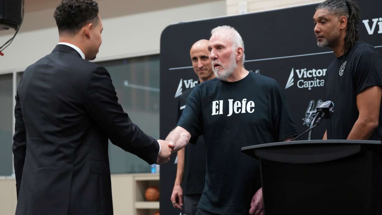 FILE - With the help of former players Manu Ginobili, back left, and Tim Duncan, right, former San Antonio Spurs head coach Gregg Popovich, center, introduces Mitch Johnson, left, as the new head coach of the San Antonio Spurs NBA basketball team, in San Antonio, May 5, 2025.