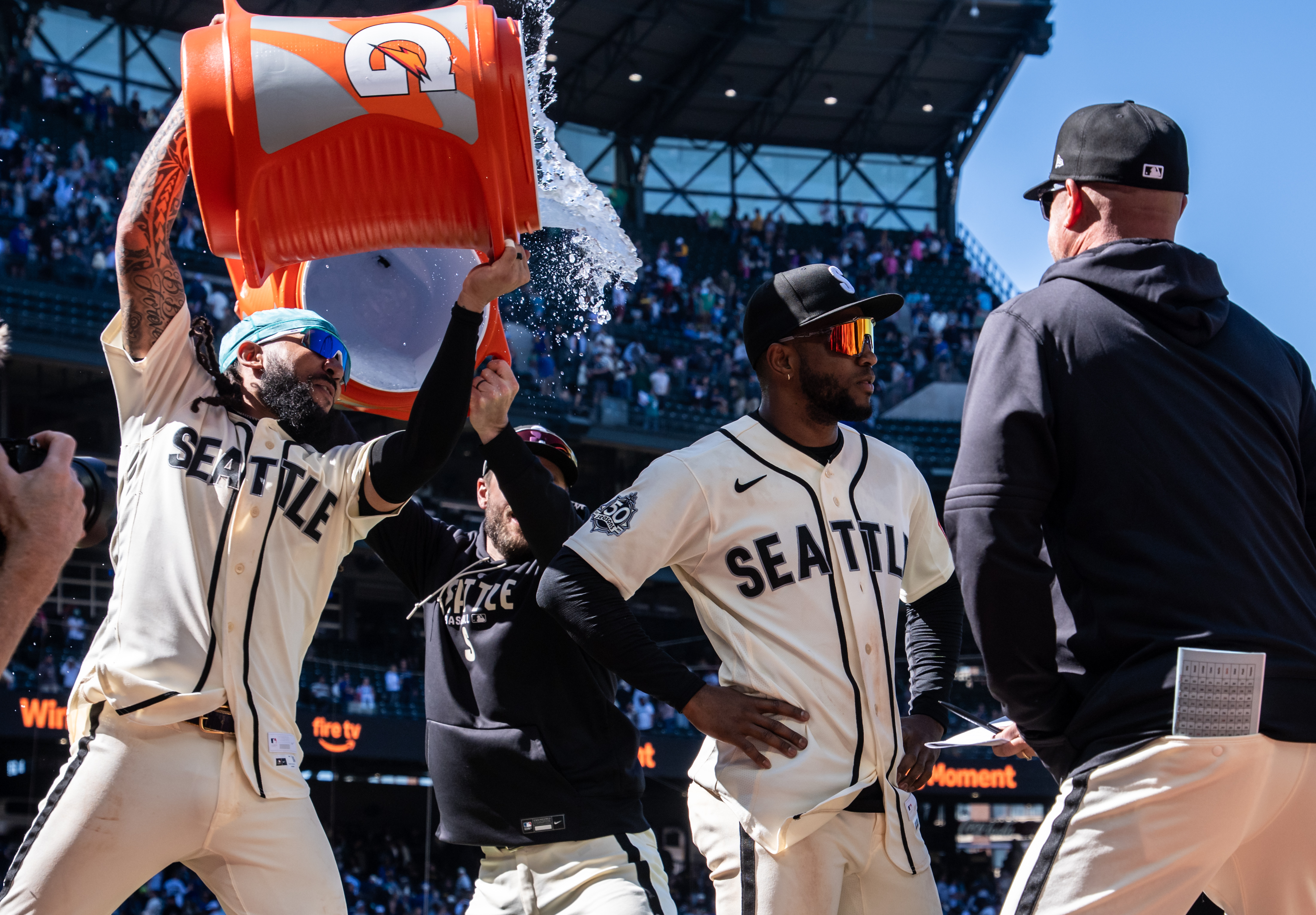 Seattle Mariners' J.P. Crawford, left, douses Victor Robles, second from right, after a baseball game against the Arizona Diamondbacks, Sunday, May 31, 2026, in Seattle. 