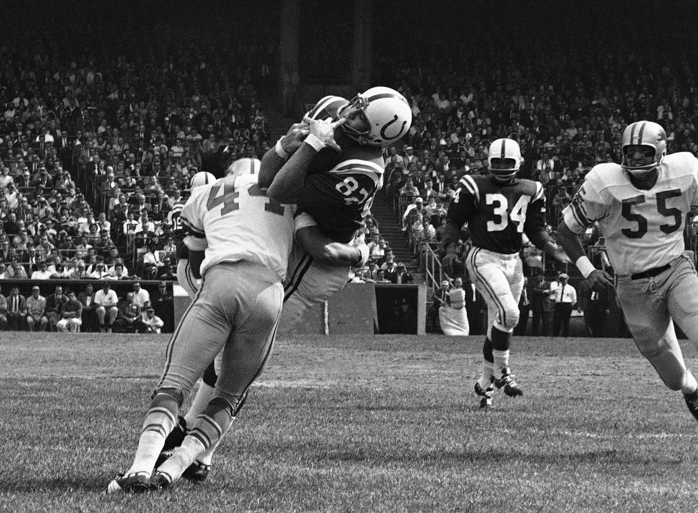 FILE - In this Sept. 30, 1962, file photo, Baltimore Colts end Raymond Berry snags a pass from quarterback John Unitas for 5-yard gain against the Detroit Lions in a football game in Baltimore. Lions' Dick LeBeau (44) makes the tackle. 