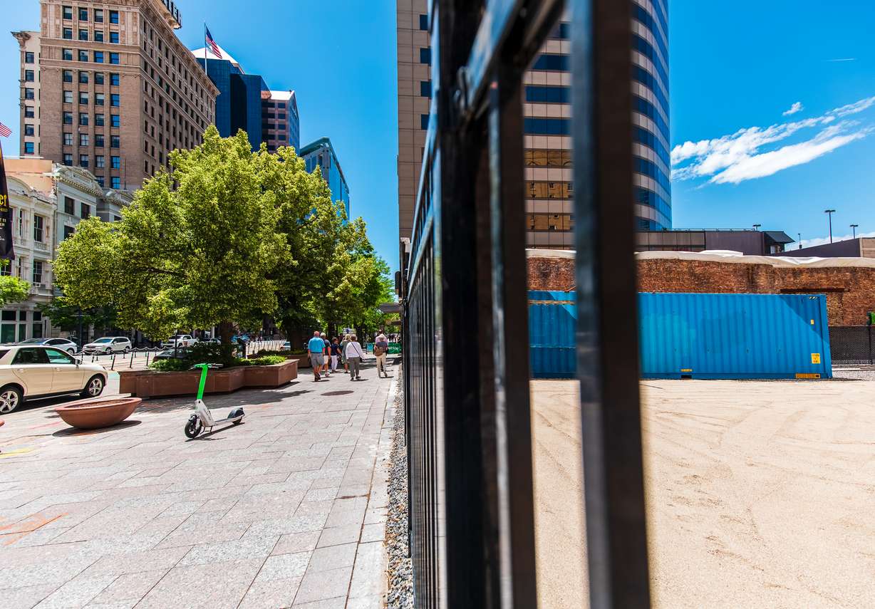 People walk down Main Street past the old Utah Pantages Theater site in downtown Salt Lake City on Monday.