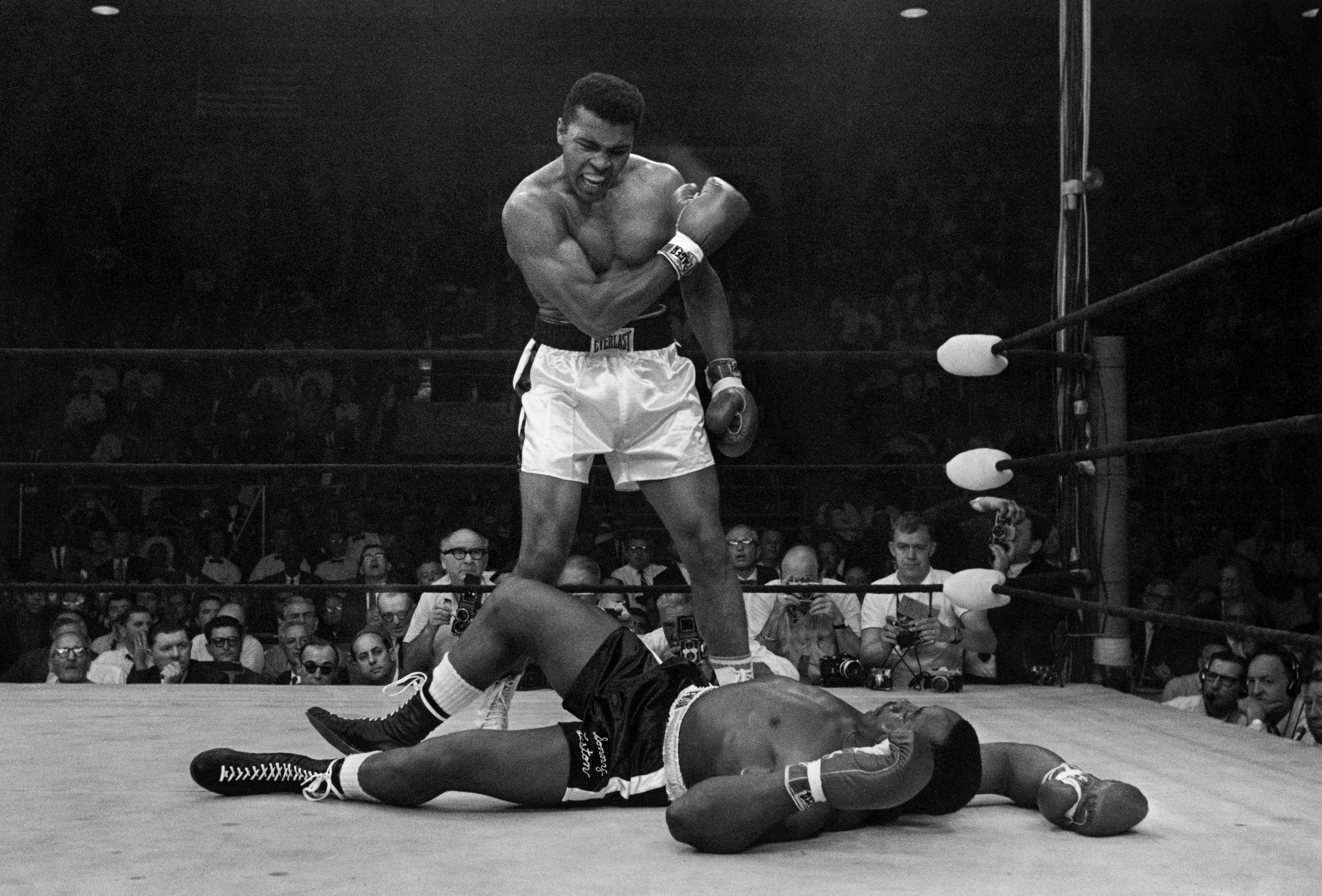 FILE - Heavyweight champion Muhammad Ali stands over fallen challenger Sonny Liston, shouting and gesturing shortly after dropping Liston with a short hard right to the jaw on May 25, 1965, in Lewiston, Maine. 