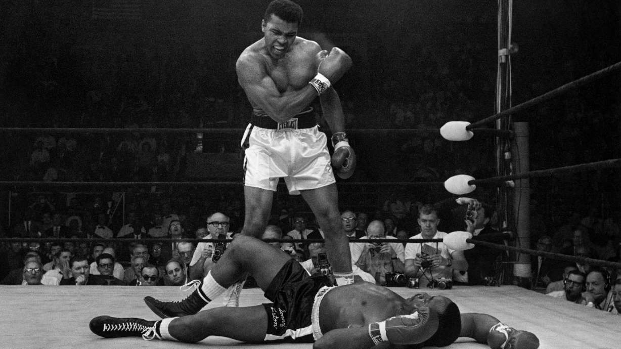 FILE - Heavyweight champion Muhammad Ali stands over fallen challenger Sonny Liston, shouting and gesturing shortly after dropping Liston with a short hard right to the jaw on May 25, 1965, in Lewiston, Maine.