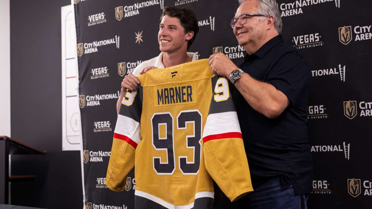 FILE - Newly-acquired Golden Knights forward Mitch Marner, left, poses for a photo with his jersey alongside general manager Kelly McCrimmon, July 1, 2025, in Las Vegas.