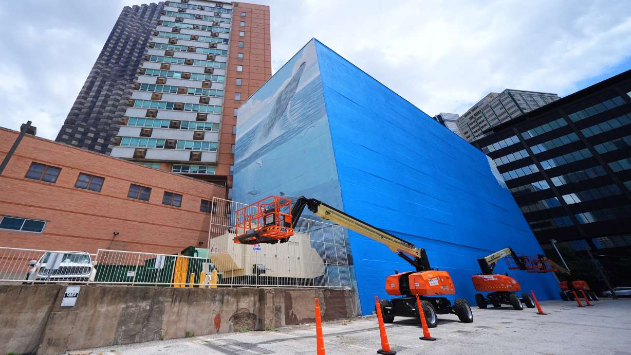 A section of a mural, known as the "Whaling Wall 82," created by artist Wyland, is visible as part of it on the right side of the building was painted over, Monday, May 18, 2026, in Dallas.