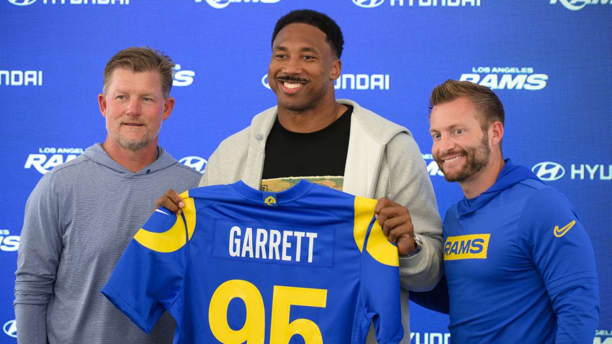 From left, Los Angeles Rams general manager Les Snead, left, defensive end Myles Garrett, and head coach Sean McVay pose for a photo during a press conference following the NFL football team's practice, Tuesday, June 2, 2026, in Woodland Hills, Calif.