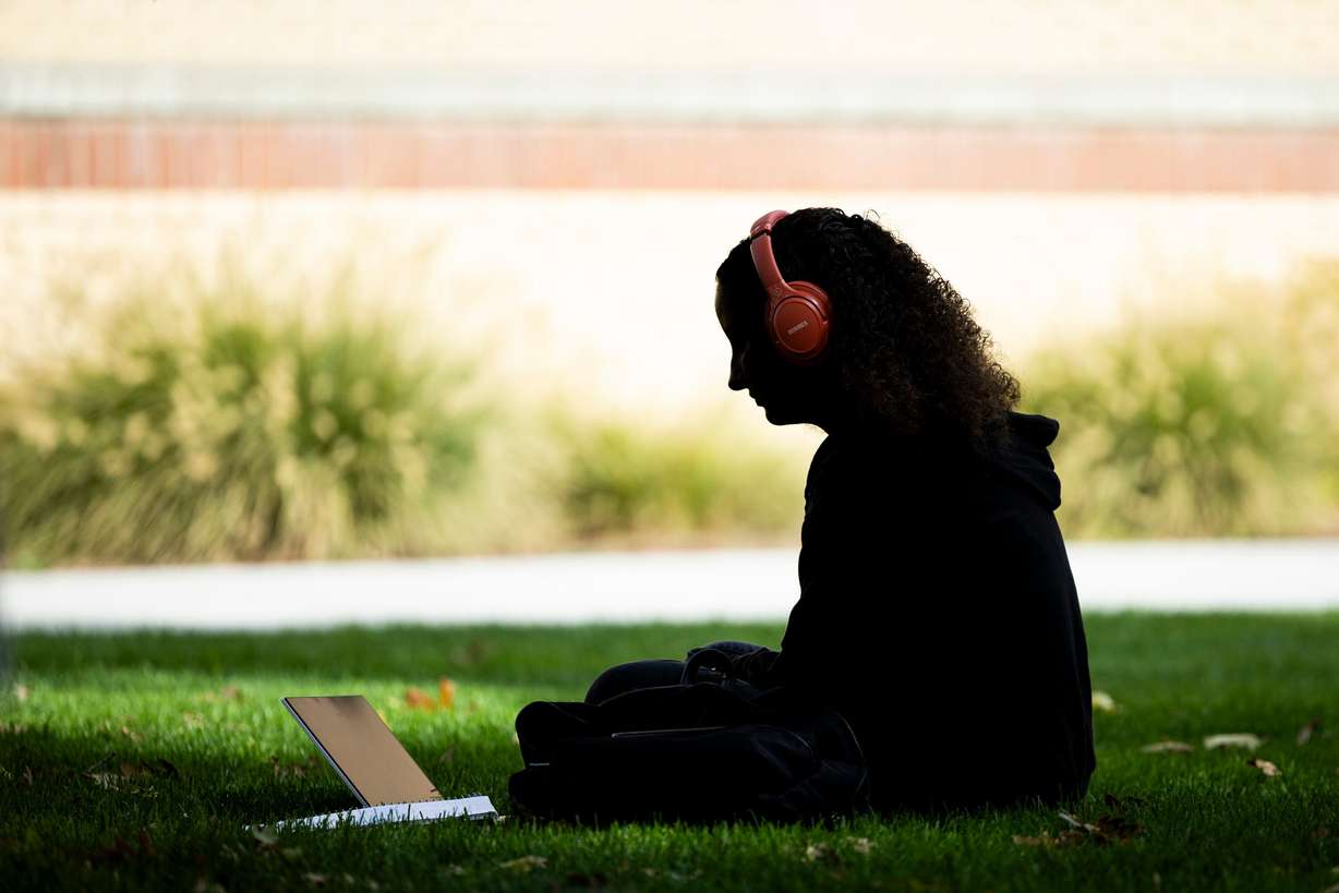 A student uses their computer on the campus of Utah State University in Logan on Oct. 1. Rep. Burgess Owens' bill to stop so-called "ghost students" will be considered by the House this week.