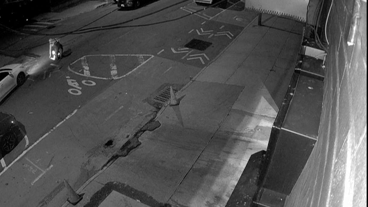 In this image from a surveillance video provided by AKI AUTO CARE, one of three people descends into a sewer on a street in New York, on May 5.
