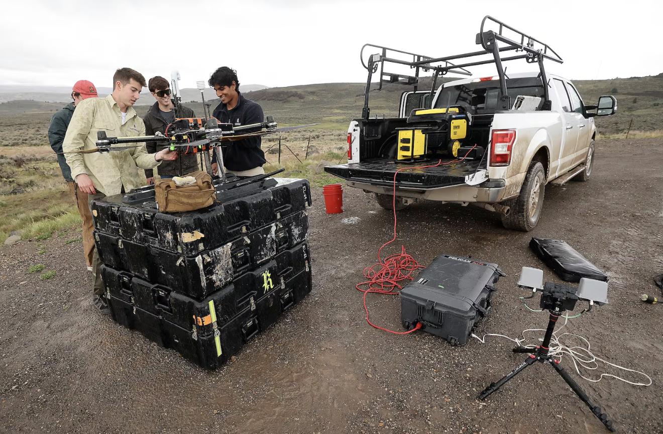 Scott Knowlton, Rainmaker senior operator, Billy Rust, Rainmaker forward deployed engineer, and Ayan Maredia, Rainmaker forward deployed engineer, talk while setting up a drone for a timed test run in Summit County on May 5.