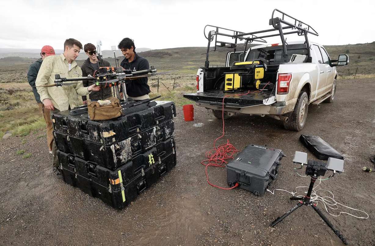 Scott Knowlton, Rainmaker senior operator, Billy Rust, Rainmaker forward deployed engineer, and Ayan Maredia, Rainmaker forward deployed engineer, talk while setting up a drone for a timed test run in Summit County on May 5.