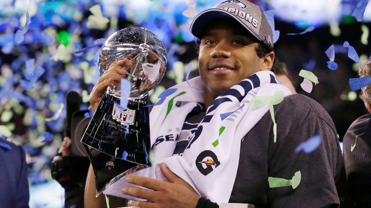 FILE - Seattle Seahawks' quarterback Russell Wilson holds the Lombardi Trophy after the NFL Super Bowl XLVIII football game, Feb. 2, 2014, in East Rutherford, N.J.