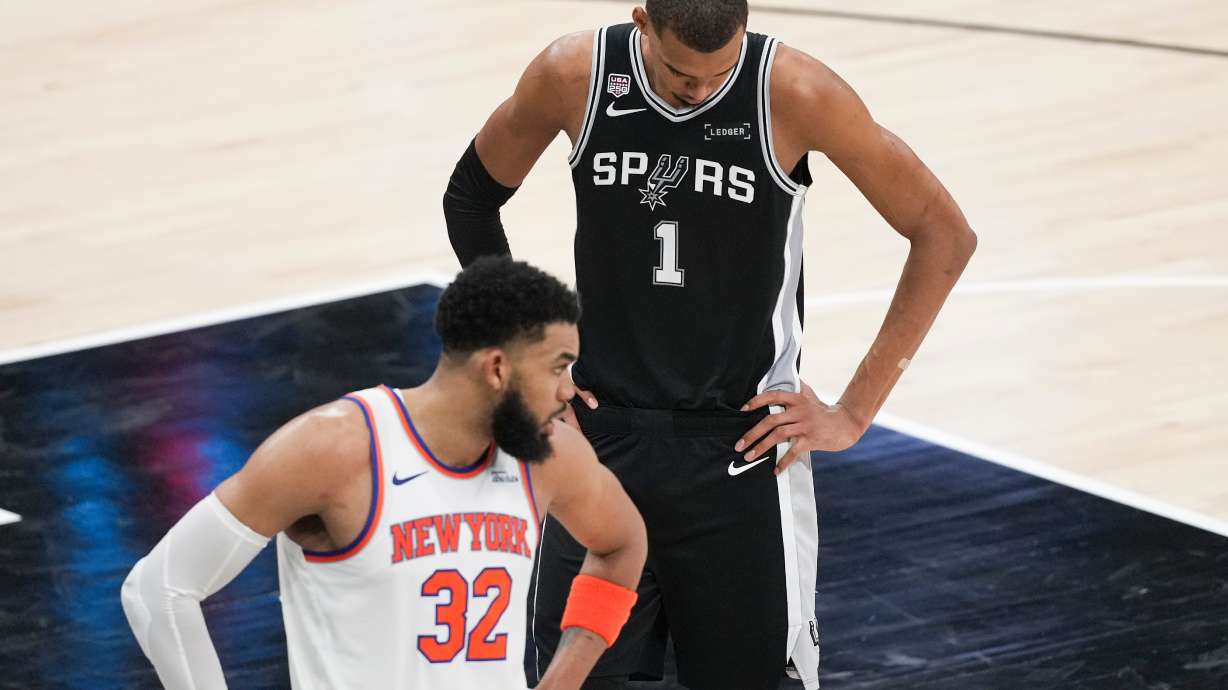 San Antonio Spurs forward Victor Wembanyama (1) looks down as New York Knicks center Karl-Anthony Towns (32) looks towards his bench during the second half of Game 1 of the NBA Finals basketball series, Wednesday, June 3, 2026, in San Antonio.