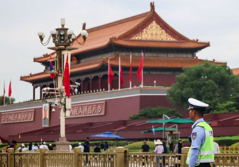 A police officer guards next to the Tiananmen Gate in Beijing, Thursday.