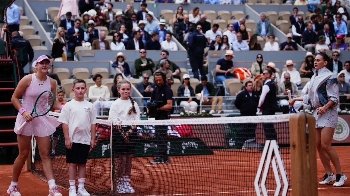 Russia's Mirra Andreeva poses with children while Ukraine's Marta Kostyuk refused during teh senifinal tennis tennis match at the French Open in Paris, Thursday, June 4, 2026.
