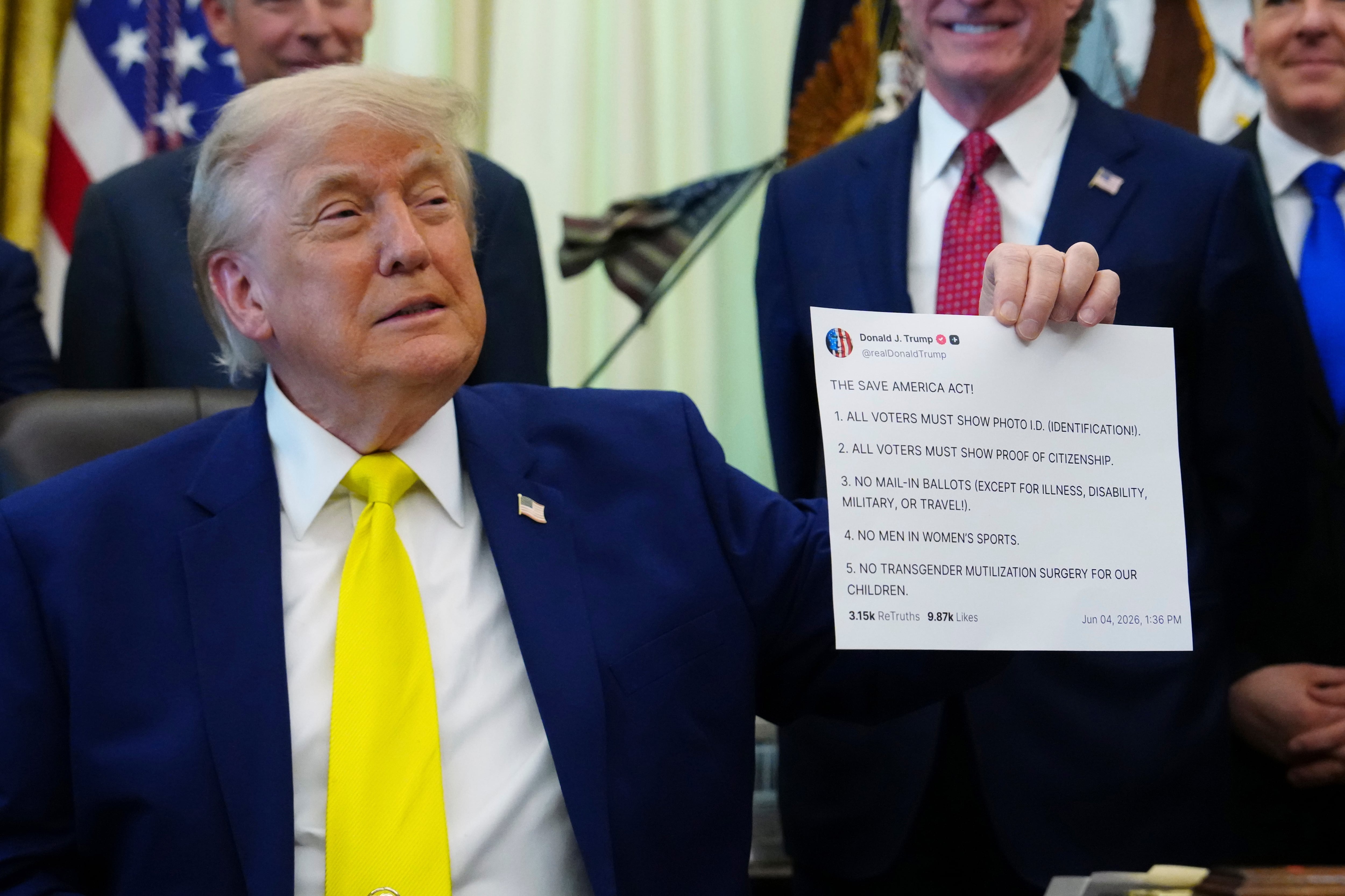 President Donald Trump holds up an image taken from his Truth Social account at an event about coal, Thursday, in the Oval Office of the White House in Washington.