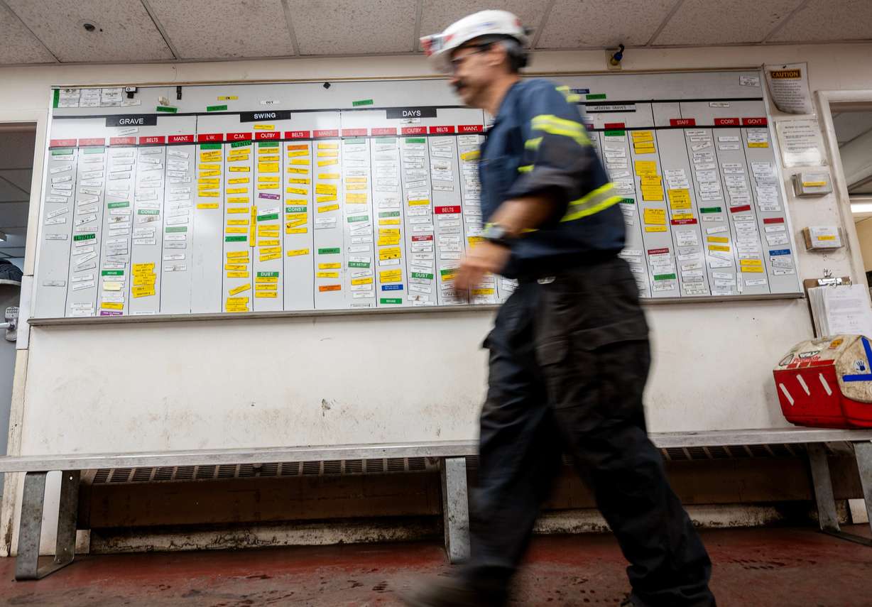 A miner walks past the name board at Sufco Mine, an underground coal mine near Salina, on Aug. 19, 2025.