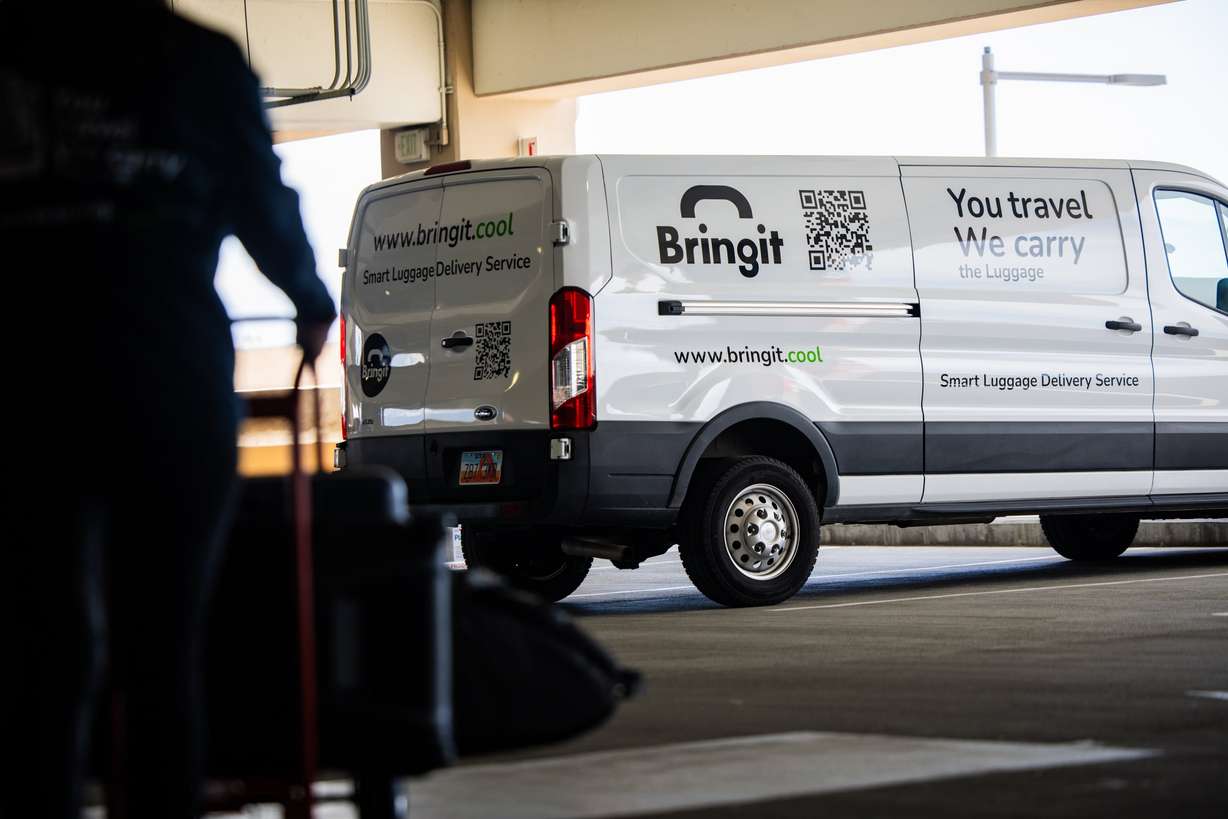 Jeanette Lee, co-founder and chief commercial officer of Bringit, prepares to deliver a customer’s luggage after picking it up at baggage claim at Salt Lake City International Airport on Wednesday. The business calls itself the DoorDash of luggage.