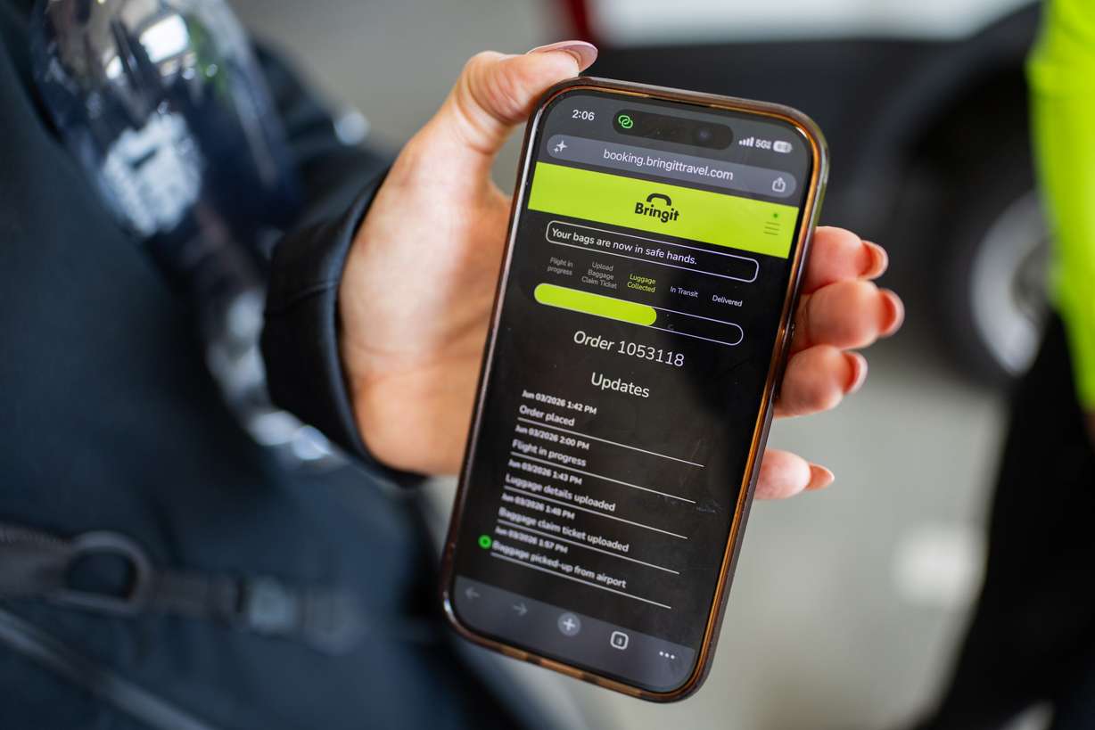 Jenn Blackham, co-founder, chief business officer and head of operations of Bringit, demonstrates to the Deseret News how a customer views the luggage delivery service on their website at Salt Lake City International Airport on Wednesday. The company calls itself "the DoorDash of luggage."