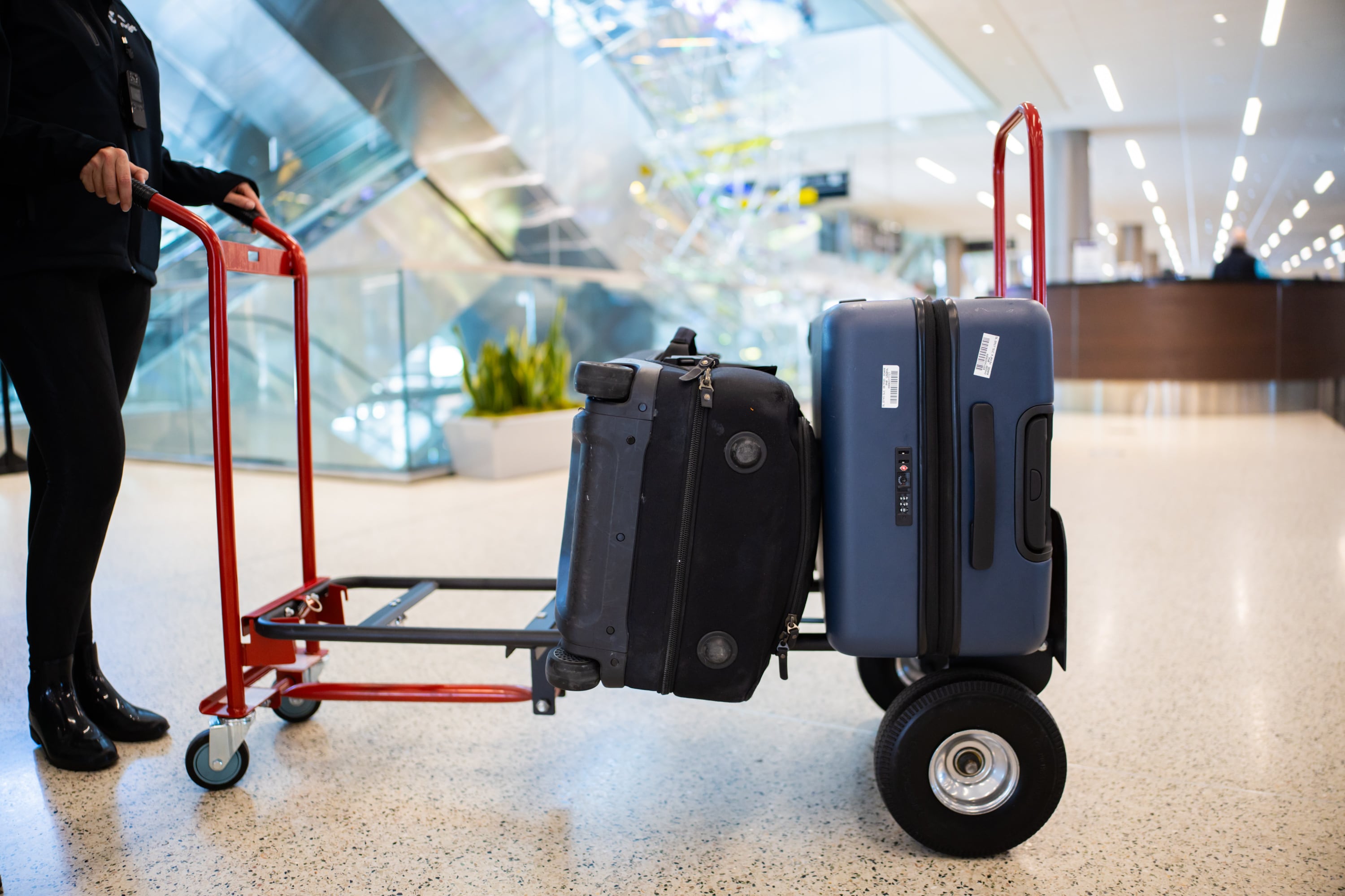 Jeanette Lee, co-founder and chief commercial officer of Bringit, wheels luggage toward a carousel in baggage claim to demonstrate picking up the luggage for customers at Salt Lake City International Airport on Wednesday. The biggest hurdle for the company is building consumer trust.