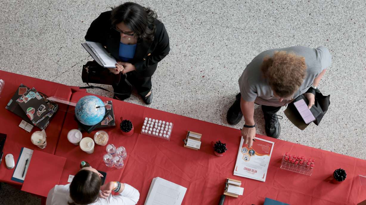 Job seekers visit a recruiting booth at a South Florida job fair on April 30.