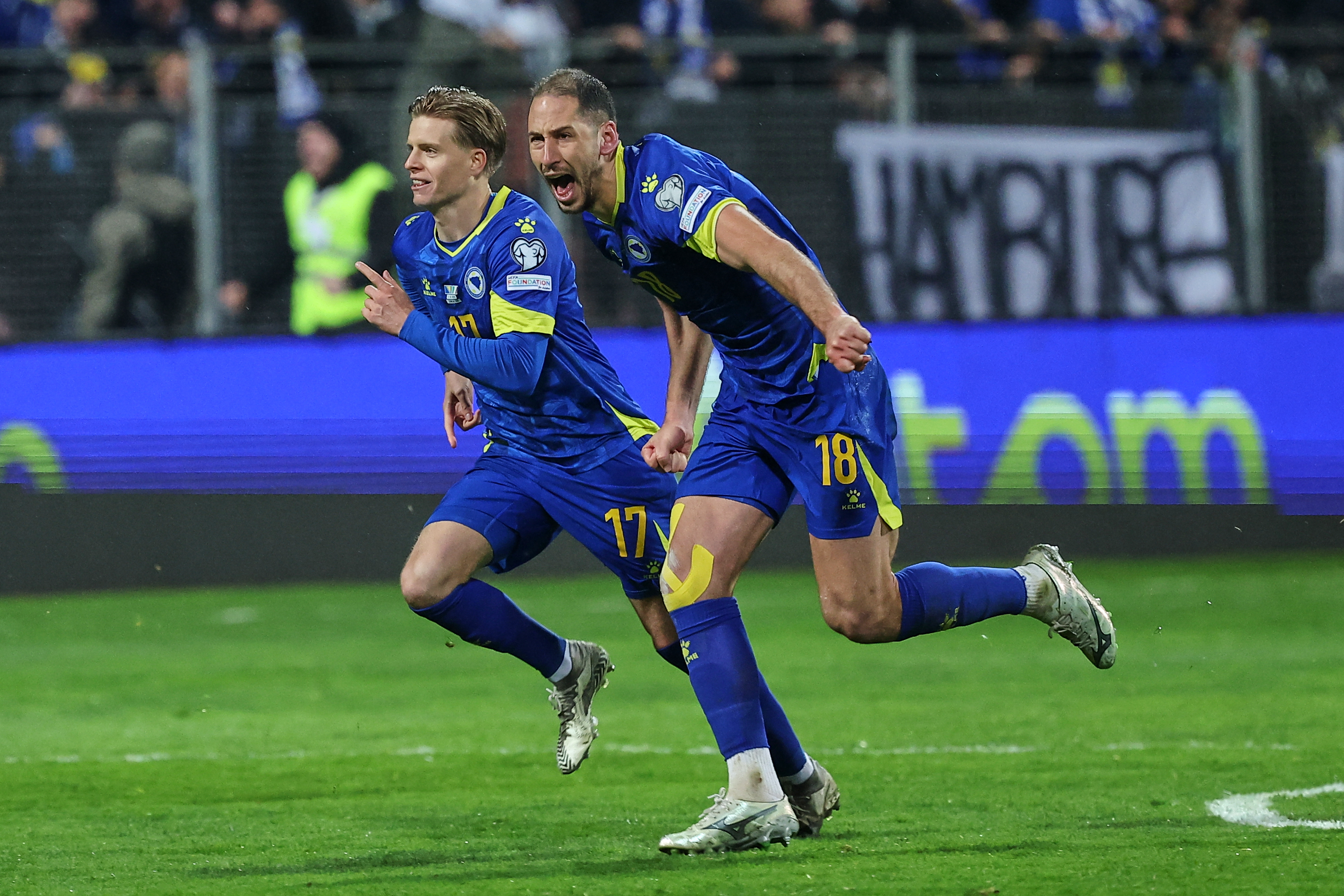 FILE - Bosnia's Nikola Katic, right, and Bosnia's Dzenis Burnic celebrate after winning a penalty shootout during the World Cup qualifying playoff final soccer match between Bosnia and Italy in Zenica, Bosnia, on March 31, 2026. 