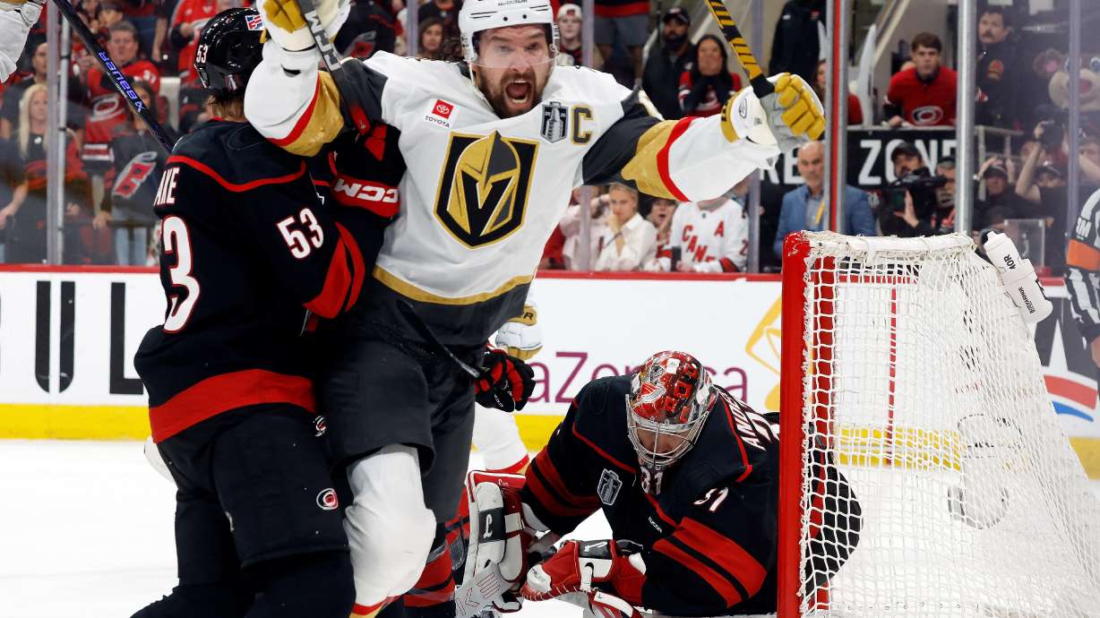 Vegas Golden Knights' Mark Stone (61) celebrates after his goal while in the grasp of Carolina Hurricanes' Jackson Blake (53) with Hurricanes goaltender Frederik Andersen, right, nearby during the third period in Game 2 of the NHL hockey Stanley Cup Final series in Raleigh, N.C., Thursday, June 4, 2026.