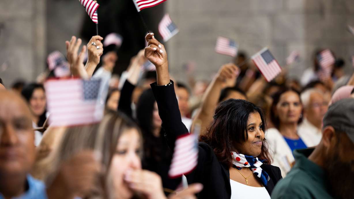 New citizens wave their flags during a naturalization ceremony at the Utah Capitol on June 20, 2024. A report from the Utah Women and Leadership Project outlines the challenges immigrant women face in Utah, as well as their contributions.